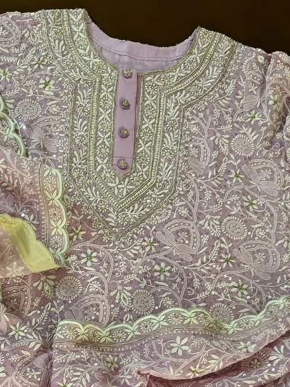 A close-up of the buttoned placket and neckline of the lilac Anarkali, revealing the precision of the hand-stitched details.