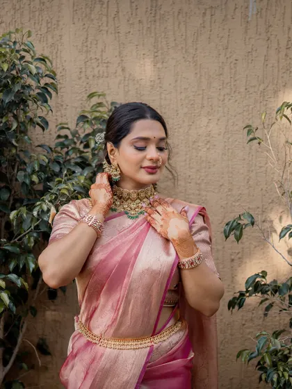 Adjusting her necklace, this pose shows off the beautiful details of her jewelry and the clean lines of the makeup.