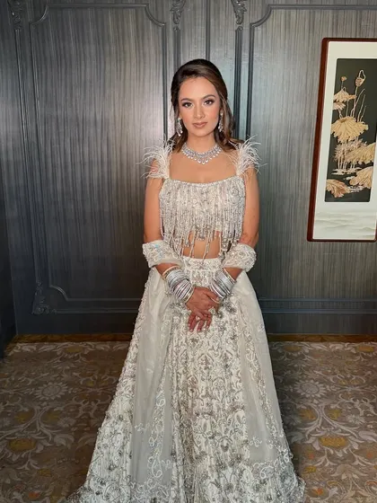 A full-length shot showing off her gorgeous fringed lehenga. The makeup is designed to be luminous and eye-catching, even from a distance.