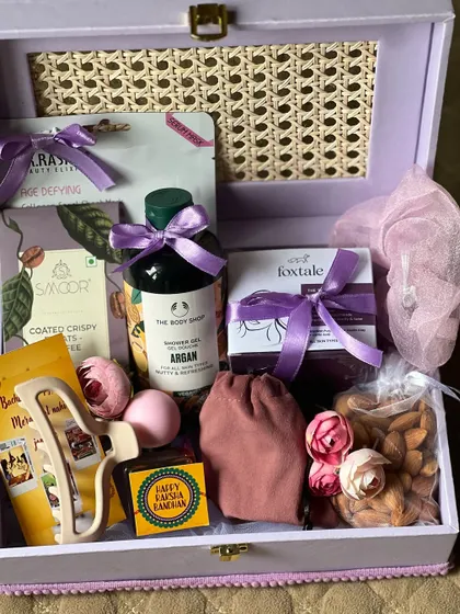 A top-down view of the sister's Rakhi hamper, showcasing the beautiful curation of purple-themed gifts.