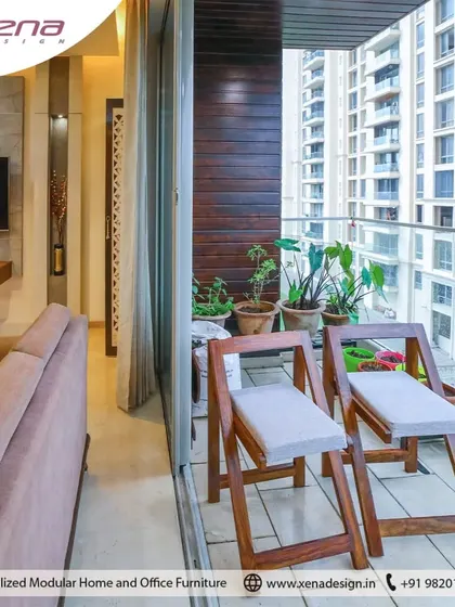 In this apartment, we designed the balcony to be an extension of the living room. Simple wooden chairs and potted plants create a perfect spot to relax with a view of the city.