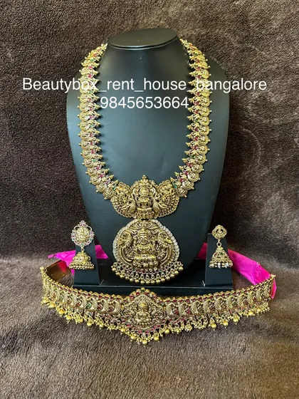 This is a grand Lakshmi bridal set with a double-pendant long necklace and a matching choker. The set is finished with an antique gold look.