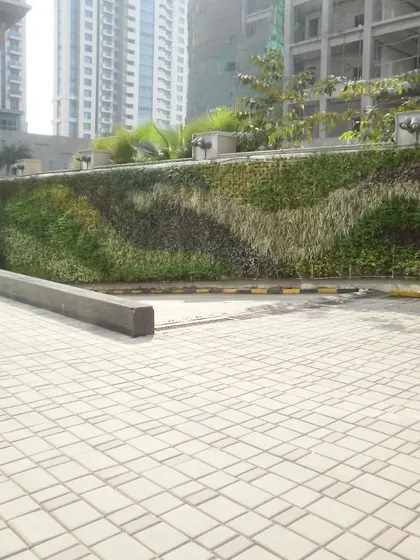 This outdoor facade features a flowing, wave-like pattern created with different plant species. We use a mix of textures and shades of green to design a living mural that changes with the seasons and adds a unique character to the building's exterior.