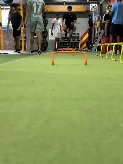 A group of athletes performs synchronized hurdle hops. This drill not only builds plyometric power but also enhances coordination and rhythm, essential components of athletic movement.