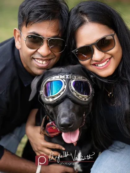 A cool family in their sunglasses, posing with their even cooler dog in his goggles. This photo is all about fun and personality.