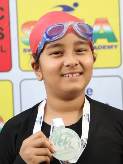 A young participant shows off her Silver medal at the Future Champions Swimming Competition. Every race is a step forward.
