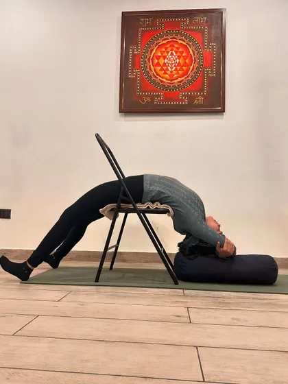 Stress weakens the immune system. Therapeutic backbends like this one, supported by a chair and bolster, lower stress hormones like cortisol and help restore balance to the body, building resilience against illness.