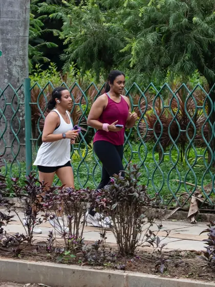 Two members running side-by-side through the greenery of Cubbon Park. Our club is a great place to find a running buddy.