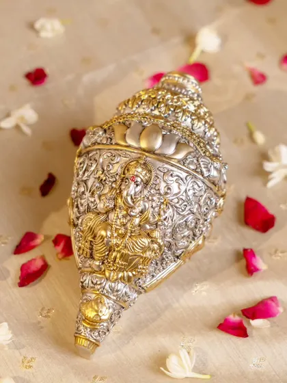 Invoking prosperity and positivity with this intricately carved silver shankh (conch) featuring Lord Ganesha. This piece of sacred art is a beautiful blend of Indian tradition and devotional elegance.
