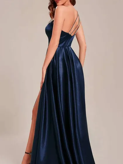 The back view of the navy one-shoulder satin gown, showcasing the delicate multi-strap detail that adds a unique touch to the open back.