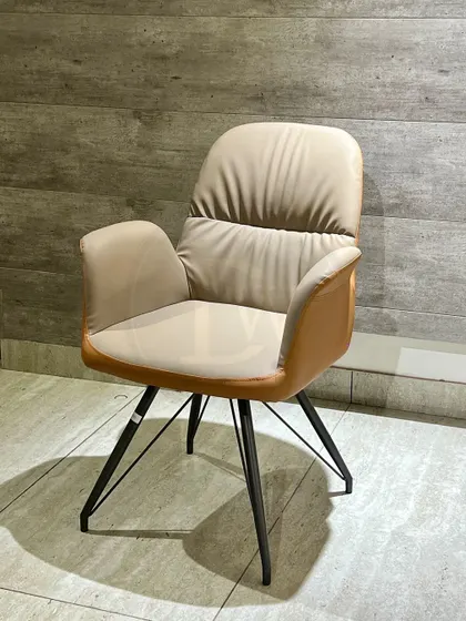 A dining chair designed for comfort. The plush, two-tone leatherette upholstery and ergonomic shape provide excellent support, while the splayed metal legs add a contemporary touch.