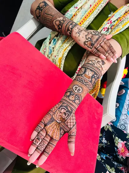 The client showing off both her hands, with one arm featuring the full baby shower design.