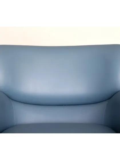 A close-up of our ultimate comfort armchair in a beautiful blue leather. The material is soft and supple, promising years of comfort and style.
