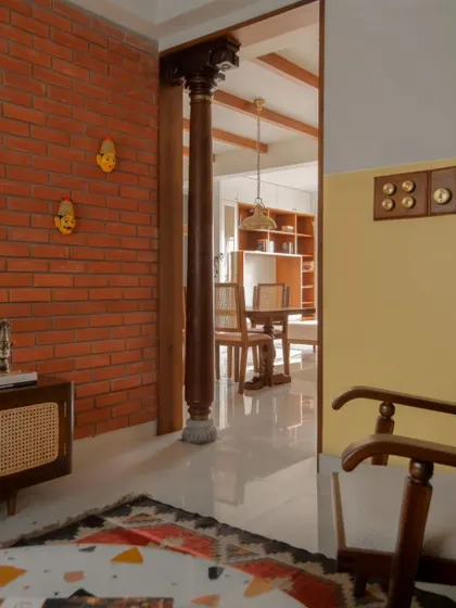 This image captures the layered view from the living area through the dining space. The traditional wooden column serves as a beautiful structural and aesthetic element, grounding the design.
