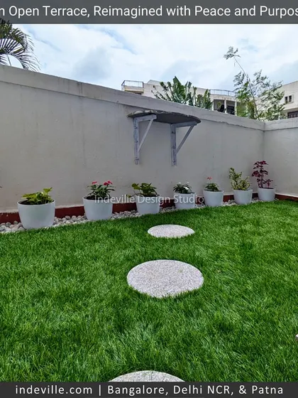 A minimalist green corner on a terrace. I used artificial turf with round stone steppers and a simple arrangement of potted plants against a white wall to create a clean and tranquil spot.