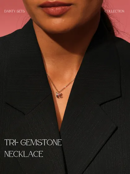 The Tri-Gemstone Necklace, worn to showcase its delicate charm. This piece features a cluster of aquamarine, citrine, and pink tourmaline.