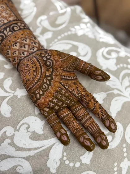 A close-up on the palm, highlighting the mix of circular motifs, fine lines, and traditional patterns.