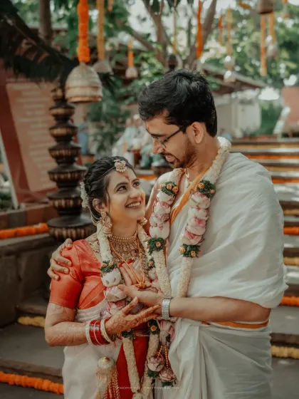 An intimate portrait capturing the loving gaze between the bride and groom, adorned in garlands.