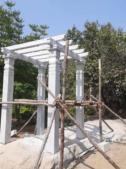 A stone pergola during the installation phase, supported by wooden scaffolding. This shows the heavy-duty construction that goes into each piece.