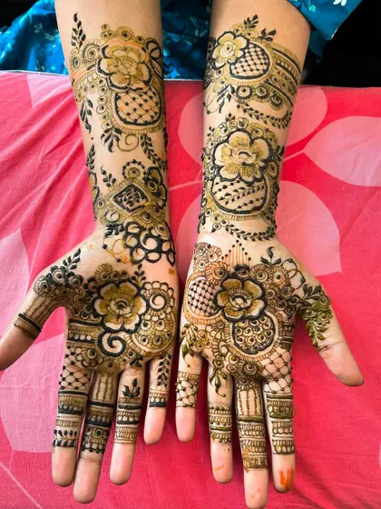 A lovely floral and checkerboard design that covers the hands and wrists. The combination of bold flowers and delicate net patterns creates a balanced and traditional look.