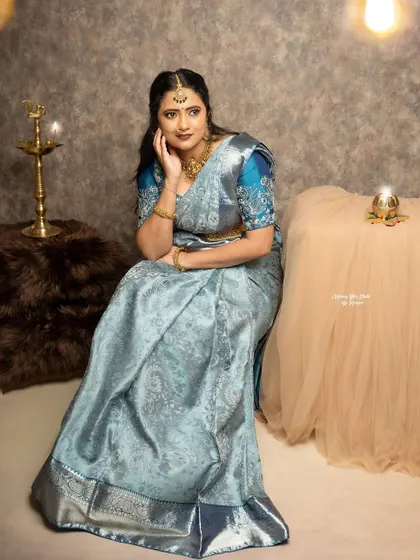 A graceful pose in the silver-blue Kanjivaram. The custom-designed blouse adds a layer of sophistication to this elegant look.