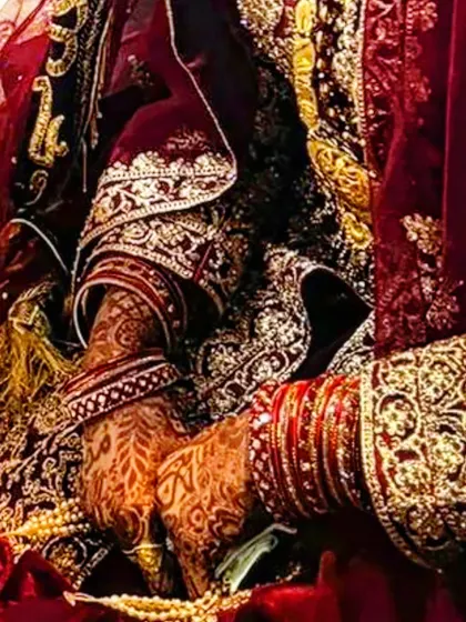 A stunning photo of a bride's hands during her wedding ceremony, showcasing the beautiful, dark henna stain.