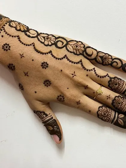 A beautiful floral vine design that wraps around the wrist and trails down the fingers, perfect for any party.