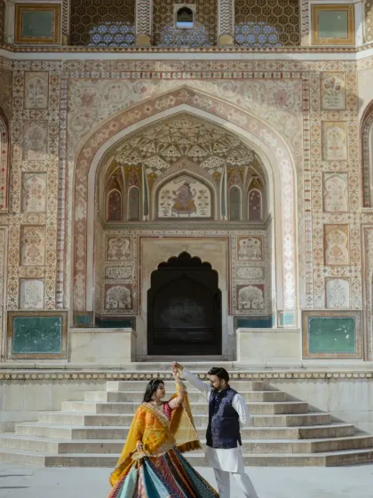 Dancing in front of the magnificent Ganesh Pol at Amber Fort. This shot captures both the grandeur of the location and the couple's happy, carefree spirit, making it a perfect pre-wedding memory.