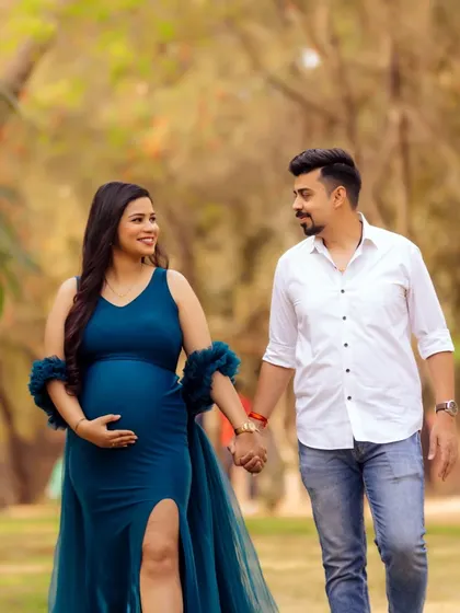 A happy, candid moment of the couple walking hand-in-hand through the park. This natural interaction is what makes for authentic and memorable maternity photography.