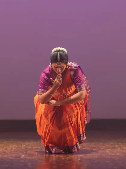 A Bharatanatyam dancer in a moment of quiet reflection on stage. This pose shows the deep emotional connection and storytelling inherent in the art form.