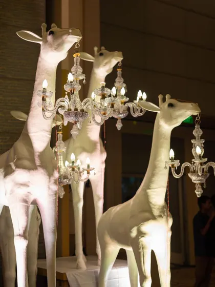 A touch of whimsical elegance for a tropical-themed Sangeet. These custom giraffe sculptures holding crystal chandeliers were a playful yet sophisticated decor element that guests absolutely loved.