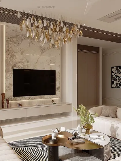 A different perspective of the beige living room, showing the TV wall with a marble backdrop and a beautiful leaf-like chandelier. These details enhance the space and give it a complete, well-designed feel.