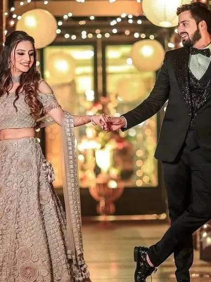 This couple's engagement look is a great mix of traditional and modern. I can create a similar embroidered lehenga and a coordinated tuxedo with a sequined vest.