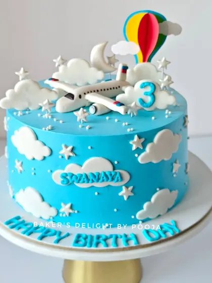 Fasten your seatbelts. This airplane-themed cake is ready for takeoff into a fun 3rd birthday celebration. The blue sky, fluffy clouds, and hot air balloon create a dreamy adventure.