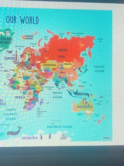 Using a world map, our guest speaker shows the children where the Galápagos Islands are, connecting their classroom theme to real-world geography.