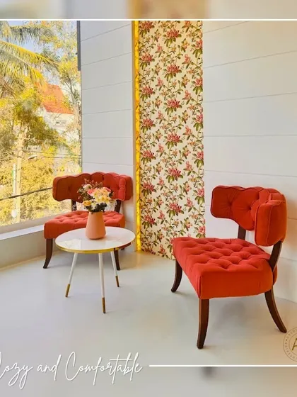 This cozy waiting corner features chic, tufted seating in a vibrant orange. I paired the chairs with a simple white side table and a floral wallpaper accent panel. This area provides a comfortable and stylish spot for clients to wait, setting a welcoming tone from the moment they arrive.