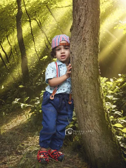 A playful moment in the woods, with sunbeams streaming through the trees. This image captures the sense of adventure and wonder that defines childhood.