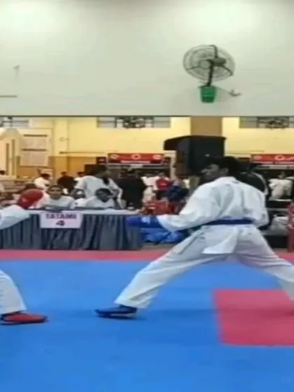 A focused shot of a student during a competitive match, showcasing the intensity and discipline required in sport karate.