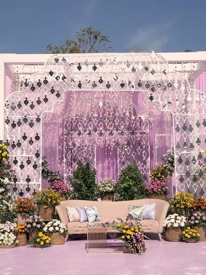 The main stage for a beautiful lavender-themed day event. The backdrop features intricate lattice work and is surrounded by a garden of colorful flowers.