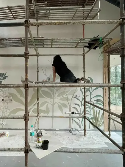 My work often takes me to great heights. Here I am on the scaffolding, adding the final details to a 20-foot high tropical mural. Every project is an adventure, and I embrace the physical challenges to bring a vision to life.