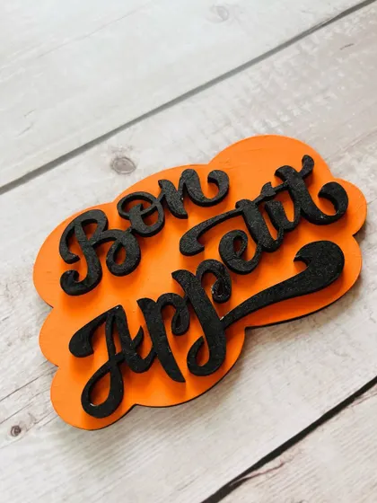 Add a touch of charm to your kitchen with this "Bon Appetit" magnet. The bright orange color and elegant script make it a lovely decorative piece.