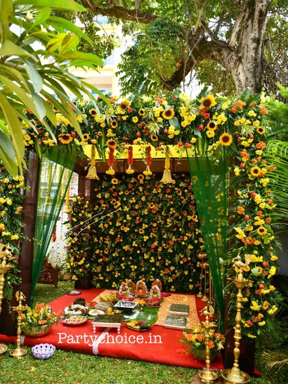 We specialize in creating beautiful outdoor settings for traditional ceremonies. This pooja mandap features a dense wall of sunflowers and marigolds, framed by a lush floral arch, perfect for housewarmings or naming ceremonies.