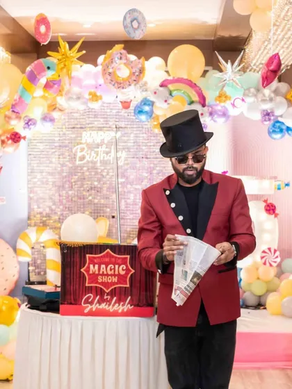 A newspaper trick in front of a colorful candyland backdrop. The vibrant theme of this party made the classic illusions even more visually exciting.