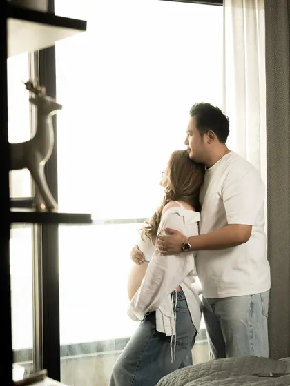 A beautiful shot of a couple looking towards the future, framed by a window with bright, natural light.