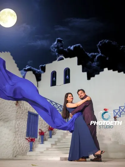 A dramatic and imaginative pre-wedding photo. We used a studio set with a painted moon and a flowing blue fabric to create this stunning, fantasy-like night scene.