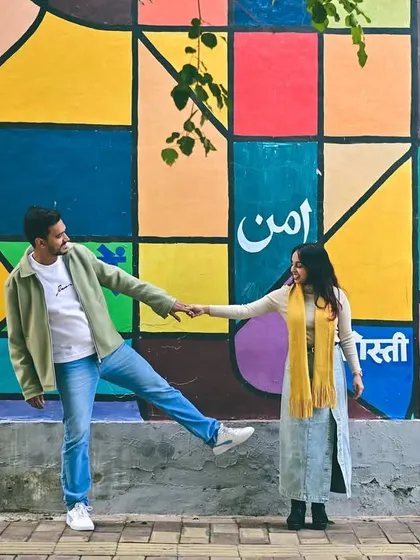 A fun, interactive pose in front of a colorful city mural. Our pre-wedding shoots are all about capturing your personalities, whether you're romantic, playful, or a bit of both.
