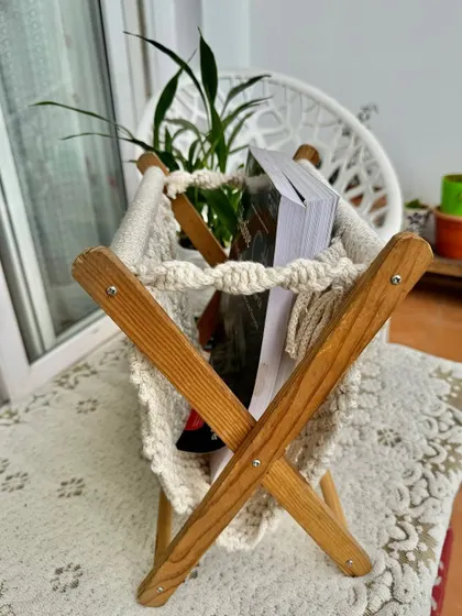 A side view of the macrame magazine stand, showing how it can hold several books or magazines.
