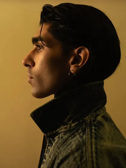 A classic profile portrait with warm, directional lighting. This highlights the model's strong features in a sophisticated way.