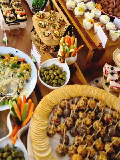 This abundant spread for a store launch features a wide variety of our finest finger foods. You can see our cheese bites, fresh vegetable crudités, capers, and a creamy pasta salad, all crafted with locally sourced ingredients.