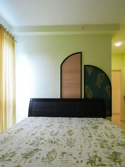 This bedroom showcases how a unique headboard design can add personality without crowding the space. The geometric, multi-panel headboard in wood and patterned fabric creates an artistic focal point in this otherwise minimalist room.